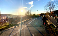 Fahrradfahrer sind im Sonnenuntergang auf der Nordbahntrasse unterwegs.